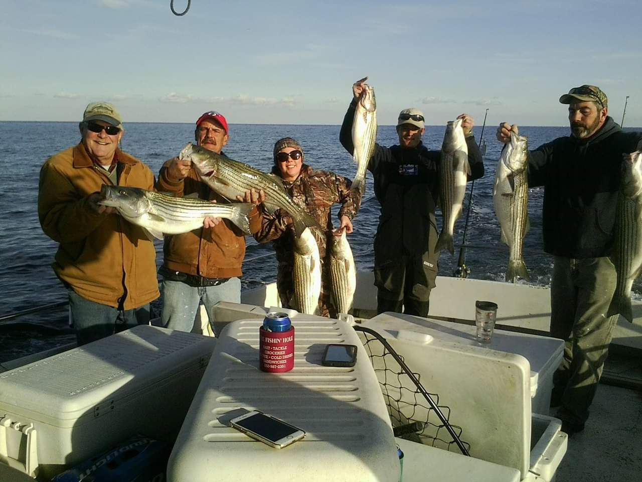 Five people holding up their fish on the charter boat