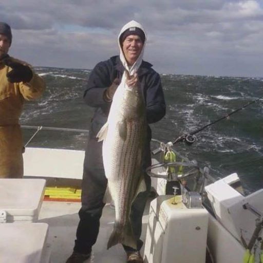 Captain Scottie holding up a large rock fish